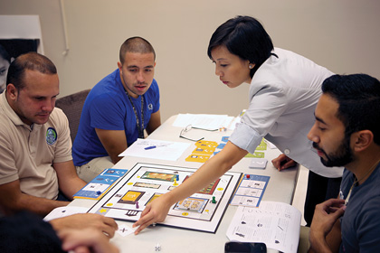 Assistant professor Lien Tran trains staff at a facility for immigrant youth to play a game that explains the U.S. legal system.