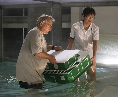 Technician Mike Rebozo, left, and Ph.D. student Ming Shao place a scale model house inside the tank during a demonstration. Photo:AP Photo/Wilfredo Lee